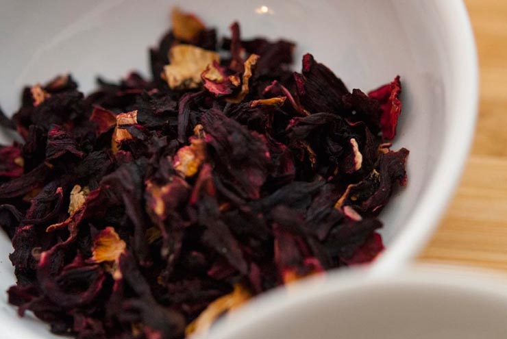 Dry hibiscus flowers in a white bowl.