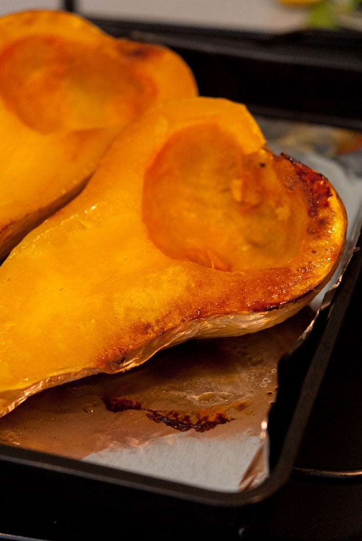 A roasted butter nut squash on a baking sheet lined with tin foil.