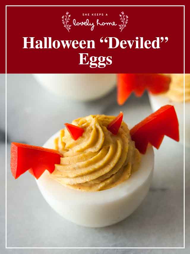 A deviled egg, garnished with pepper wings and horns with a title that says "Halloween 'Deviled' Eggs."