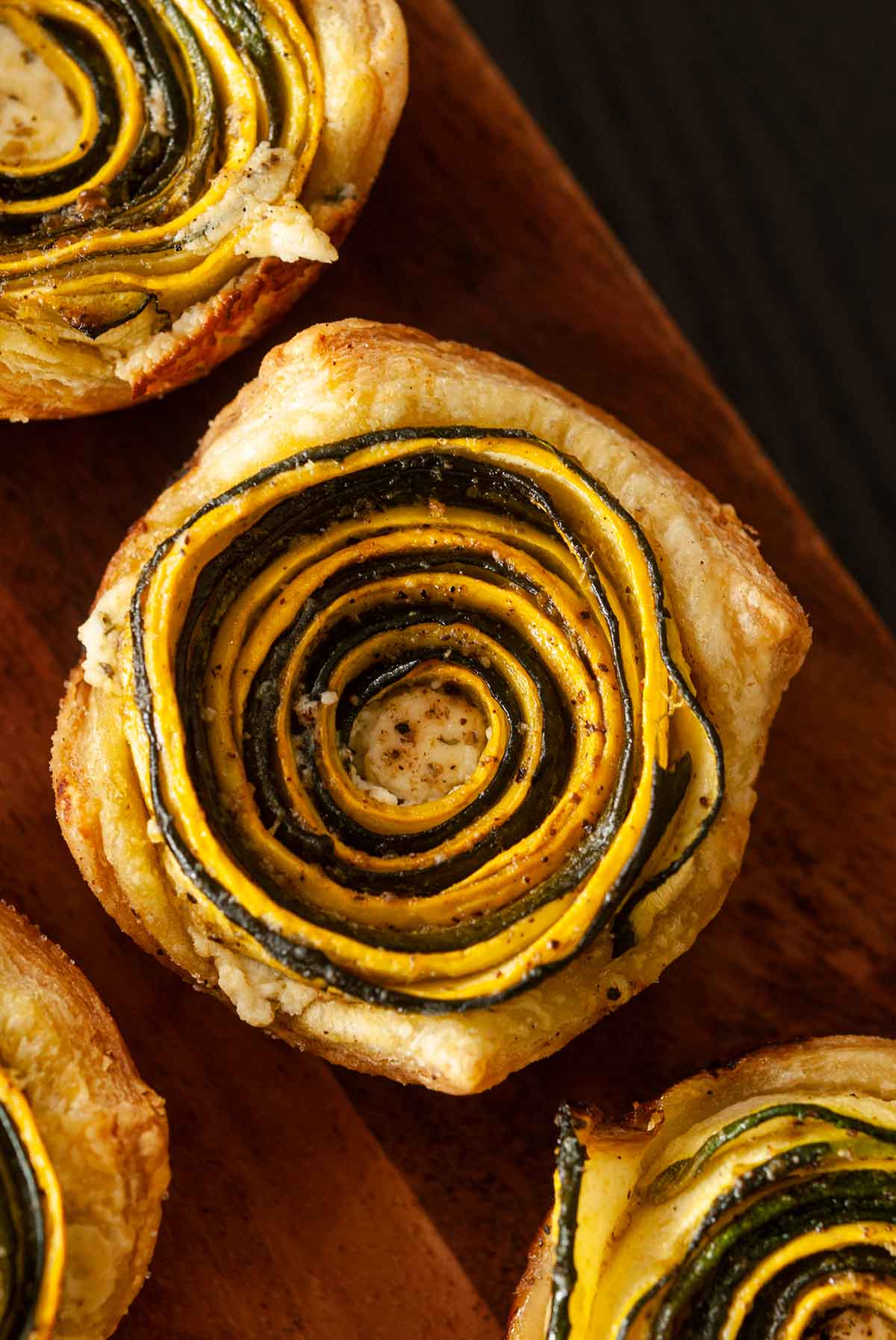 3 zucchini rosettes on a wooden board.