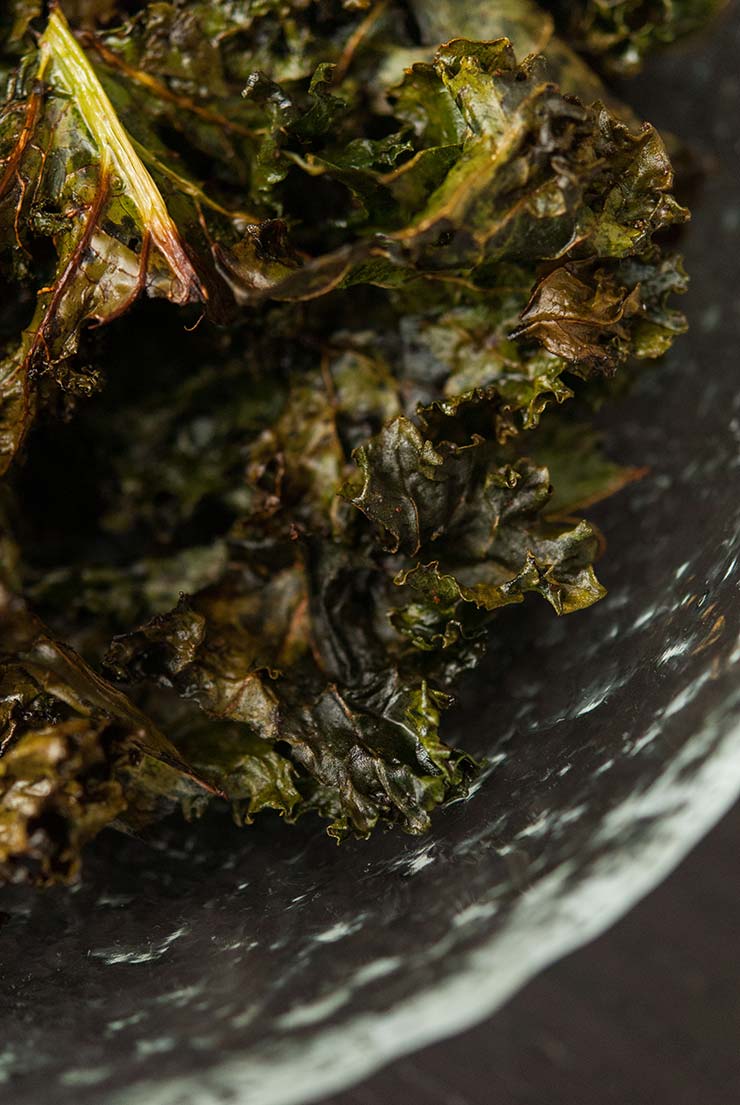 A glass bowl of kale chips.