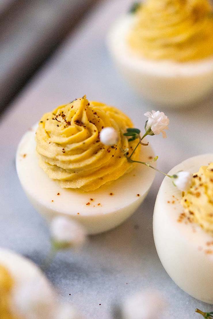 A deviled egg, garnished with thyme and baby's breath.
