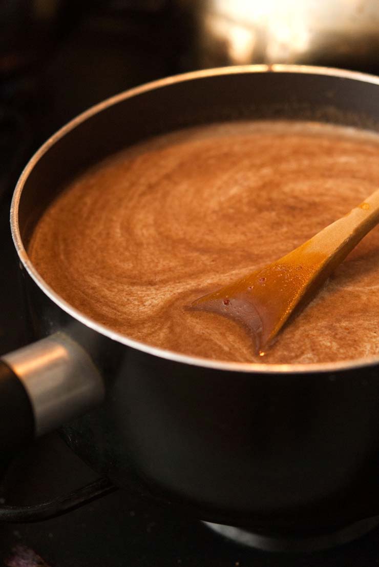 A pot on a stove with a spiral of spices in Mexican cream chocolate liqueur.