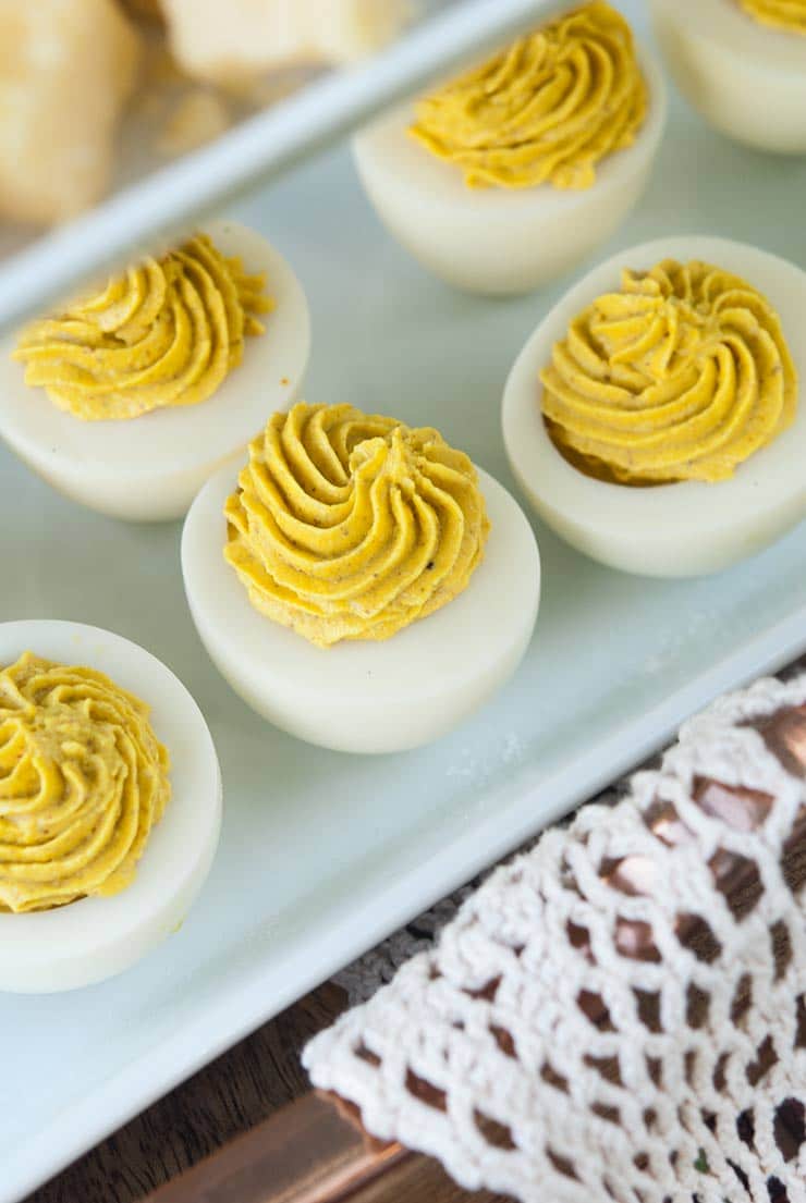 Deviled eggs on a white tray with lace.
