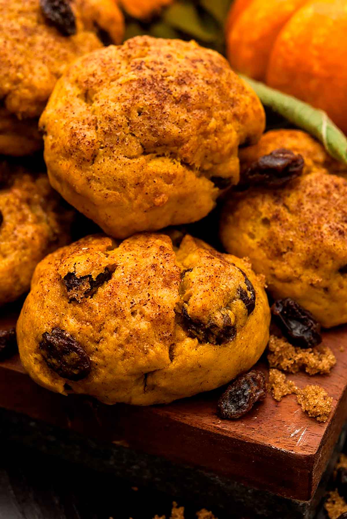 Pumpkin scones on a wooden board with a small pumpkin in the background.