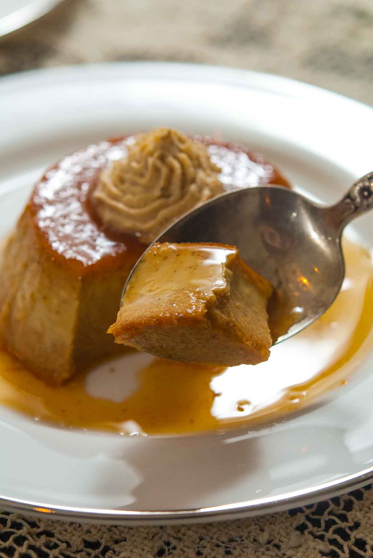 A spoon cutting into pumpkin flan.