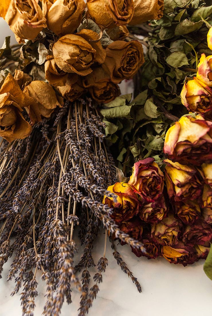 Bunches of roses and lavender on a while marble table top.