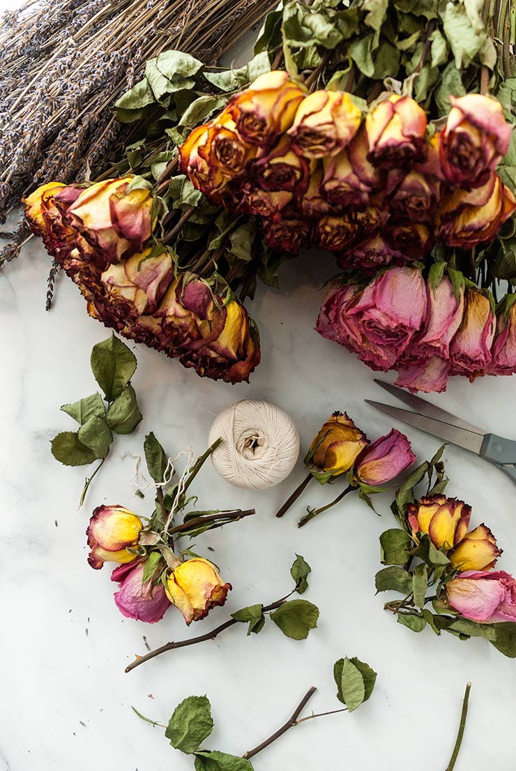 Flowers, scissors and a ball of string on a marble table.