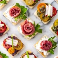 A marble appetizer tray of 8 canapés in 3 different styles.