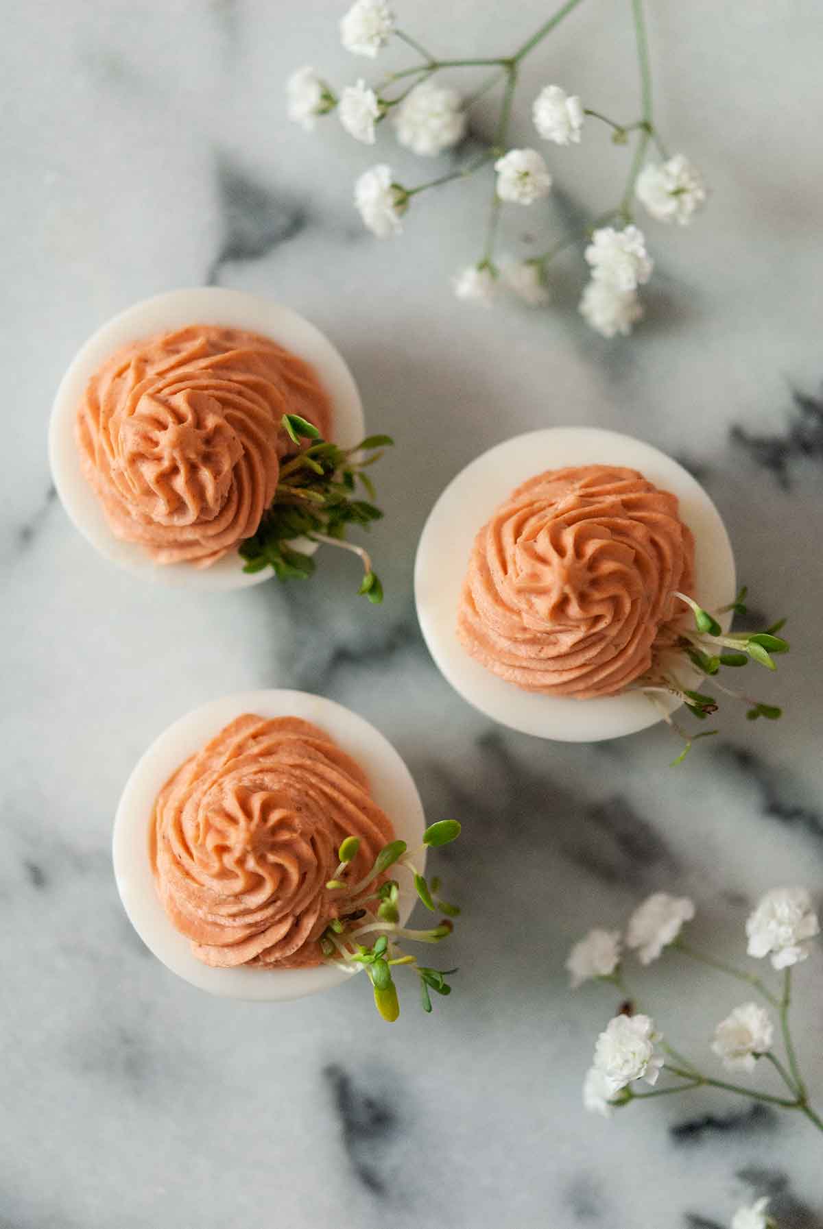 3 pink deviled eggs on marble.