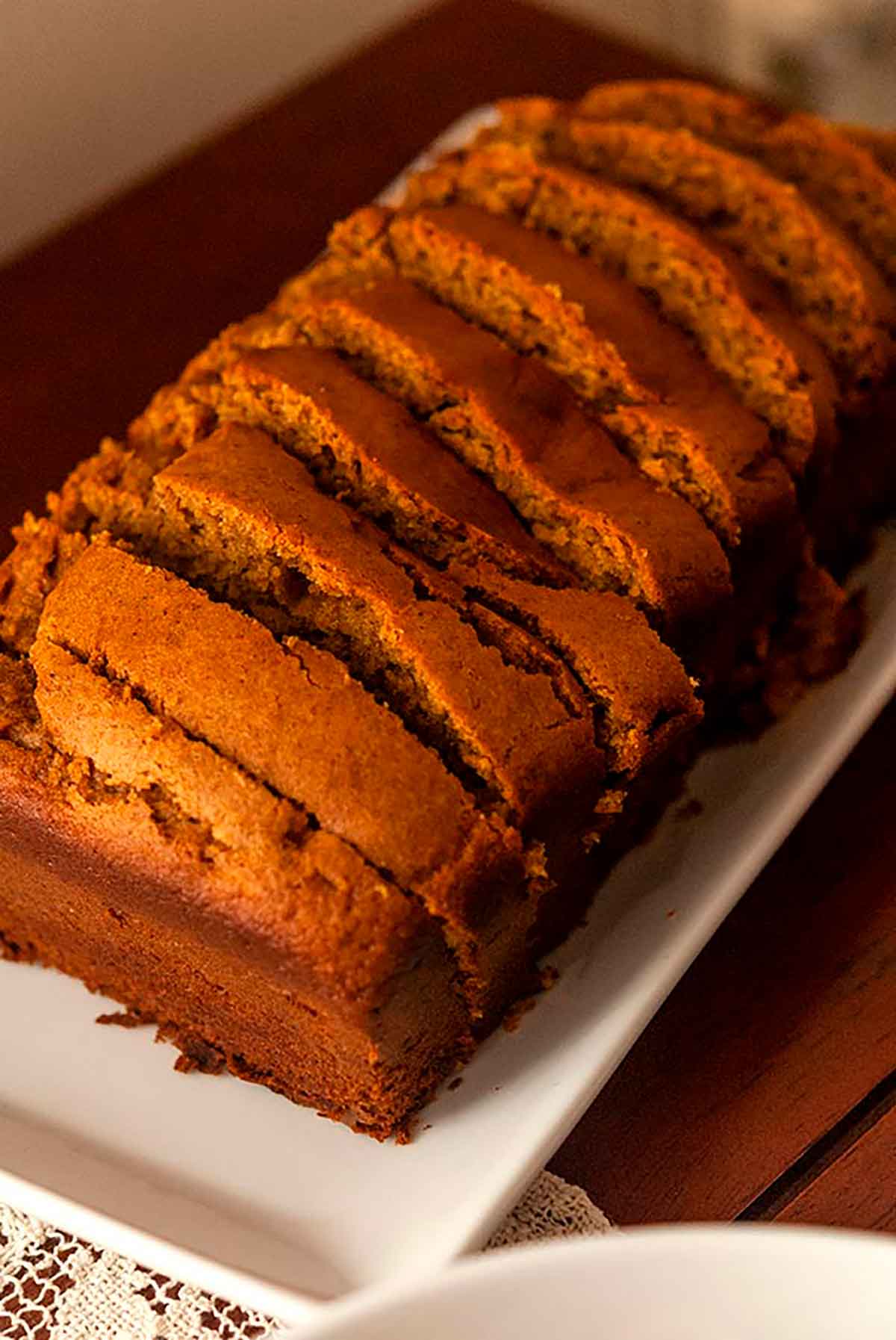 A sliced loaf of pumpkin bread on a plate.