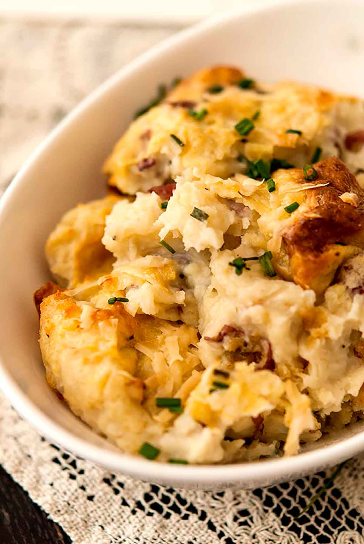 Baked masked potatoes in a pyrex dish, garnished with chives.