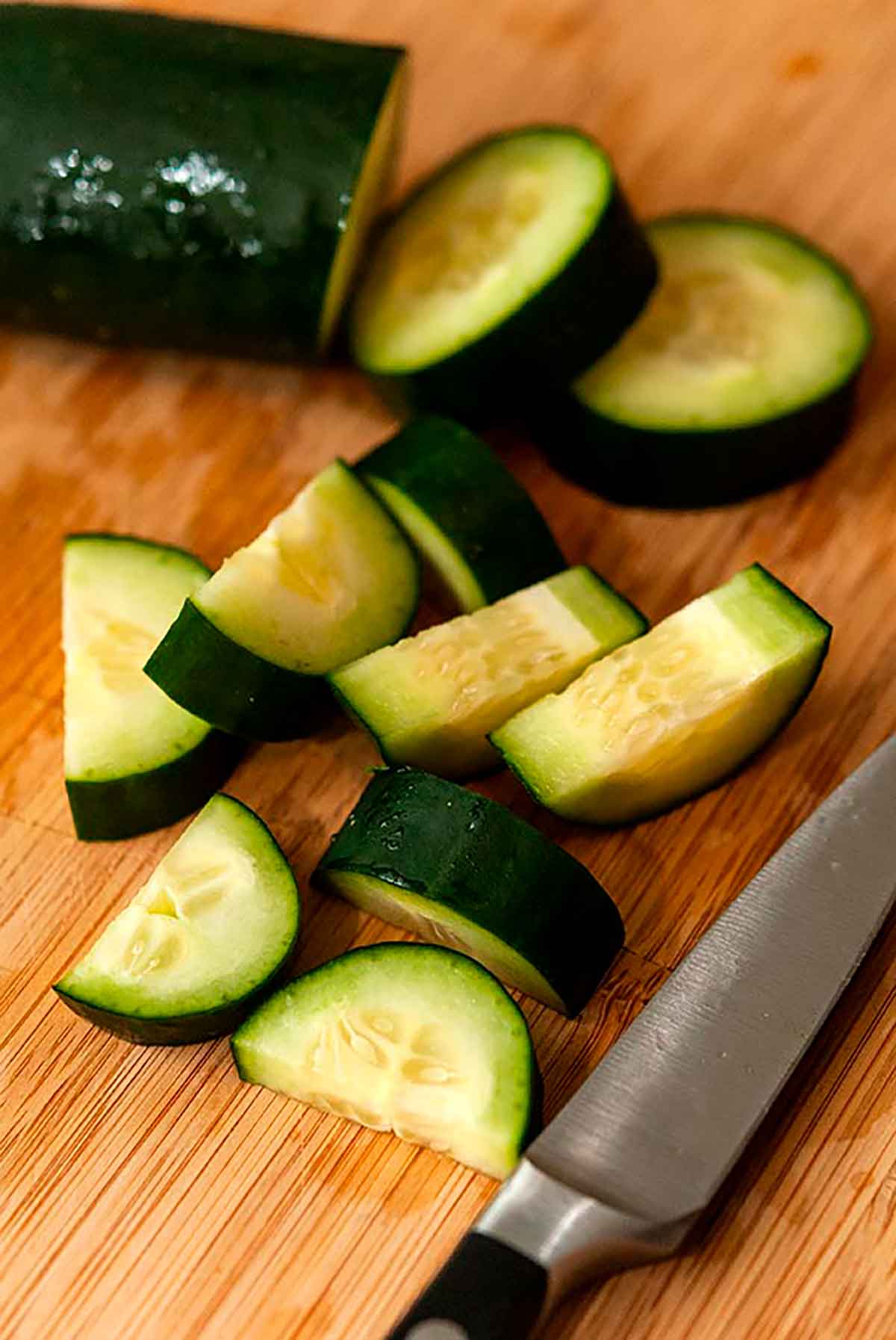 A sliced cucumber on a cutting board.