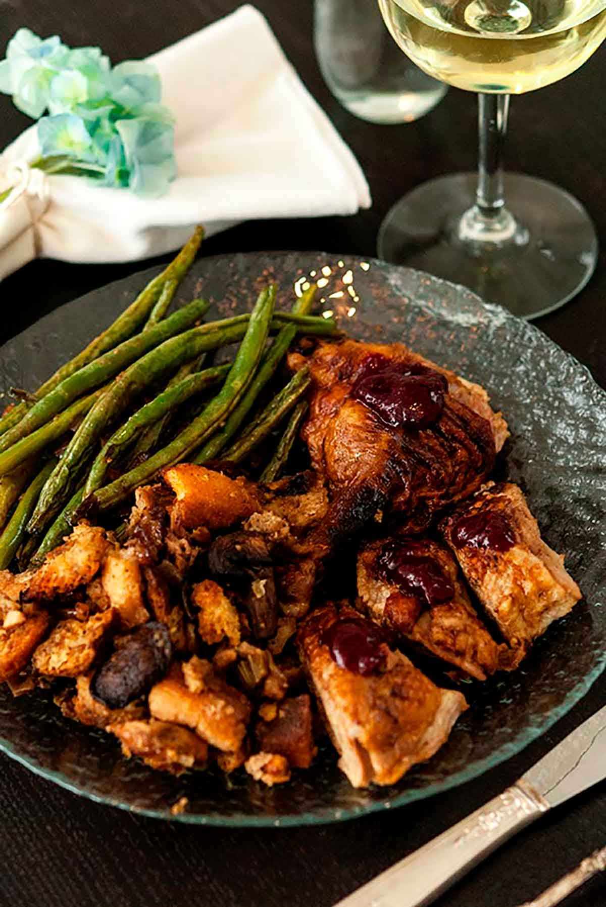 A plate with beans, duck and stuffing.