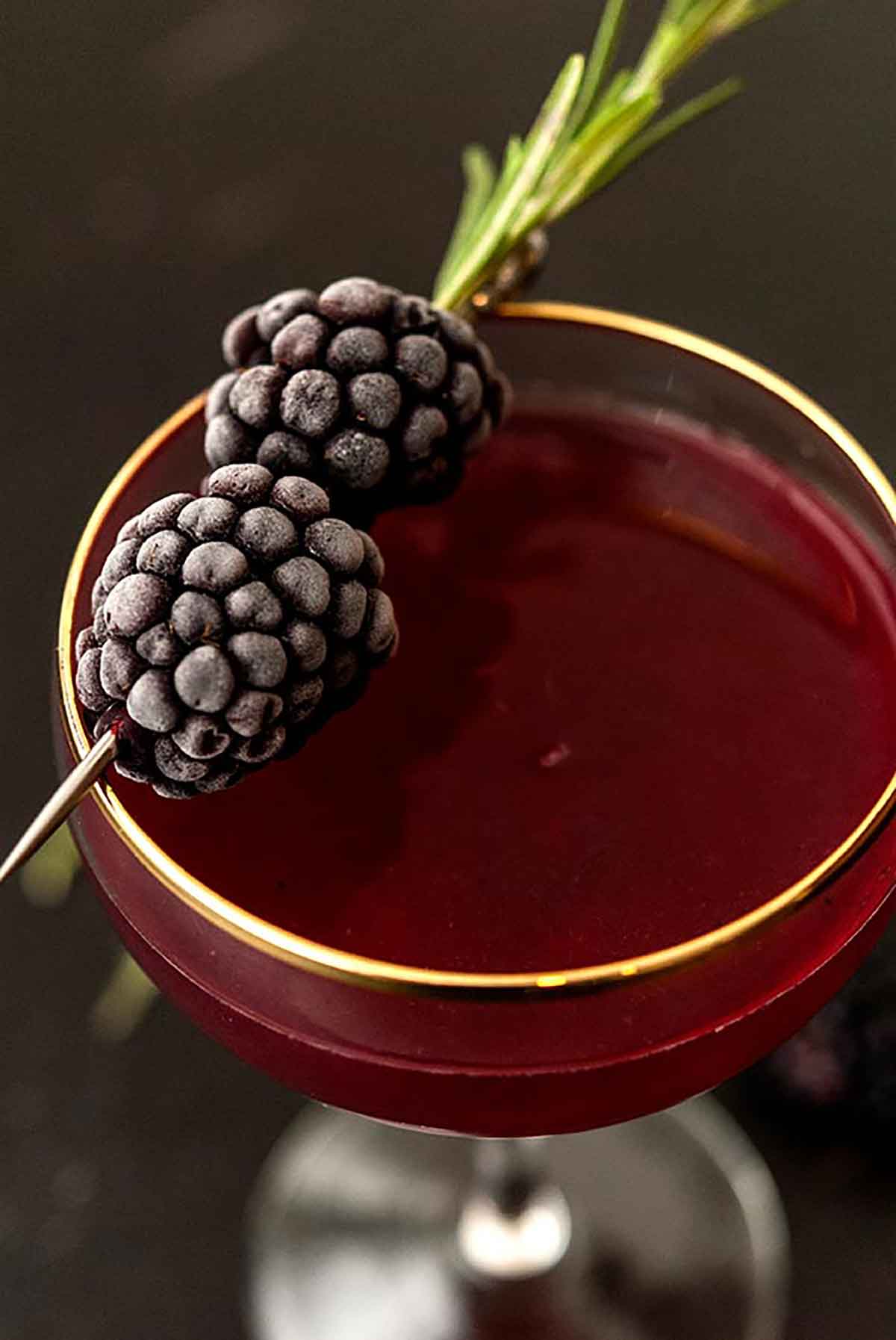The frosted blackberry garnish on a cocktail.