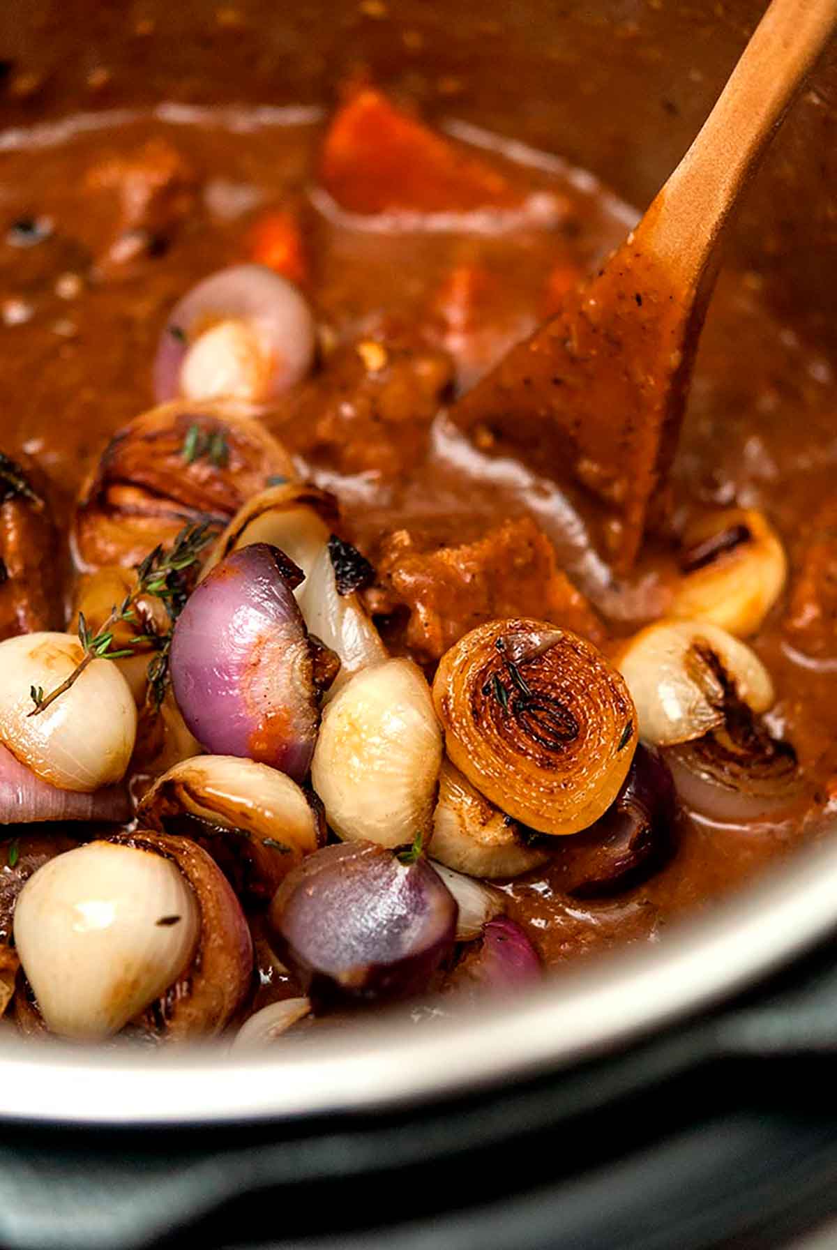 Beef Bourguignon in an Instant Pot with a wooden spoon.