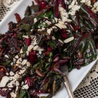 A plate of Swiss chard on a lace table cloth.