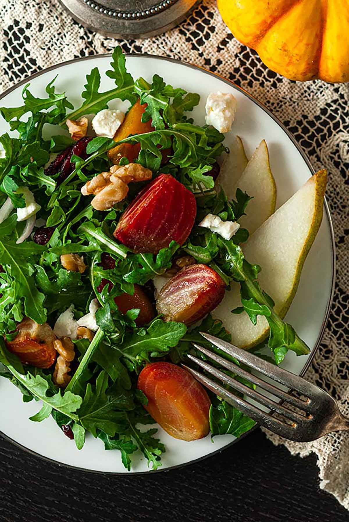 A beet and pear salad on a plate, on a lace table cloth.