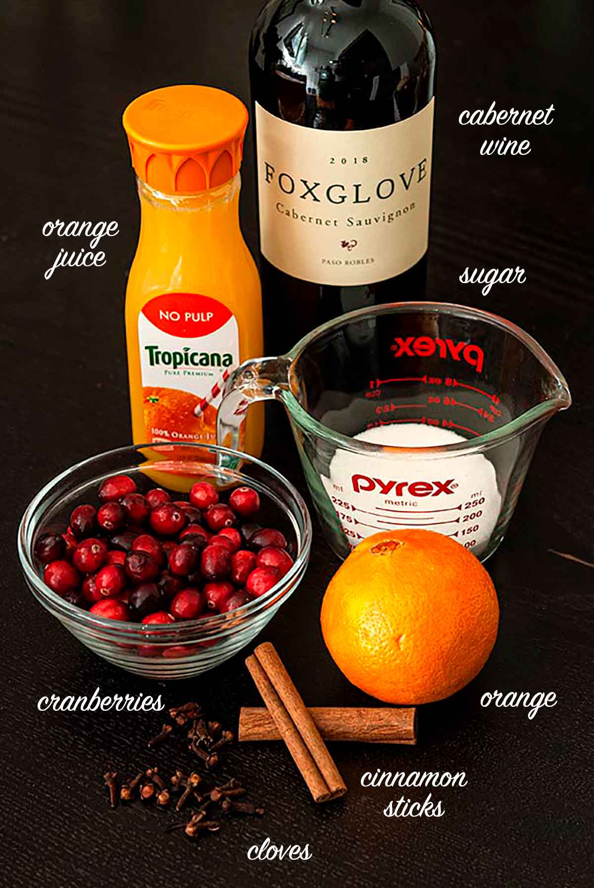 A group of ingredients for spiced Cabernet cranberry sauce on a table.