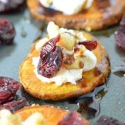 3 sweet potato rounds, garnished with cheese, cranberries and crushed nuts.