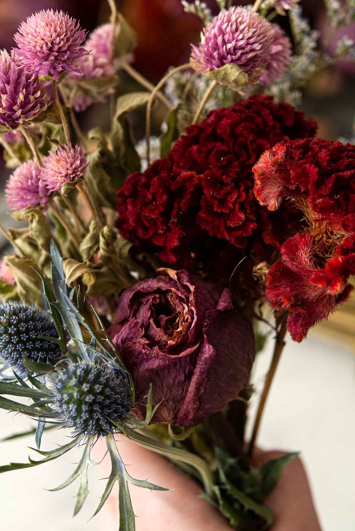 A hand holding a small bouquet of flowers.