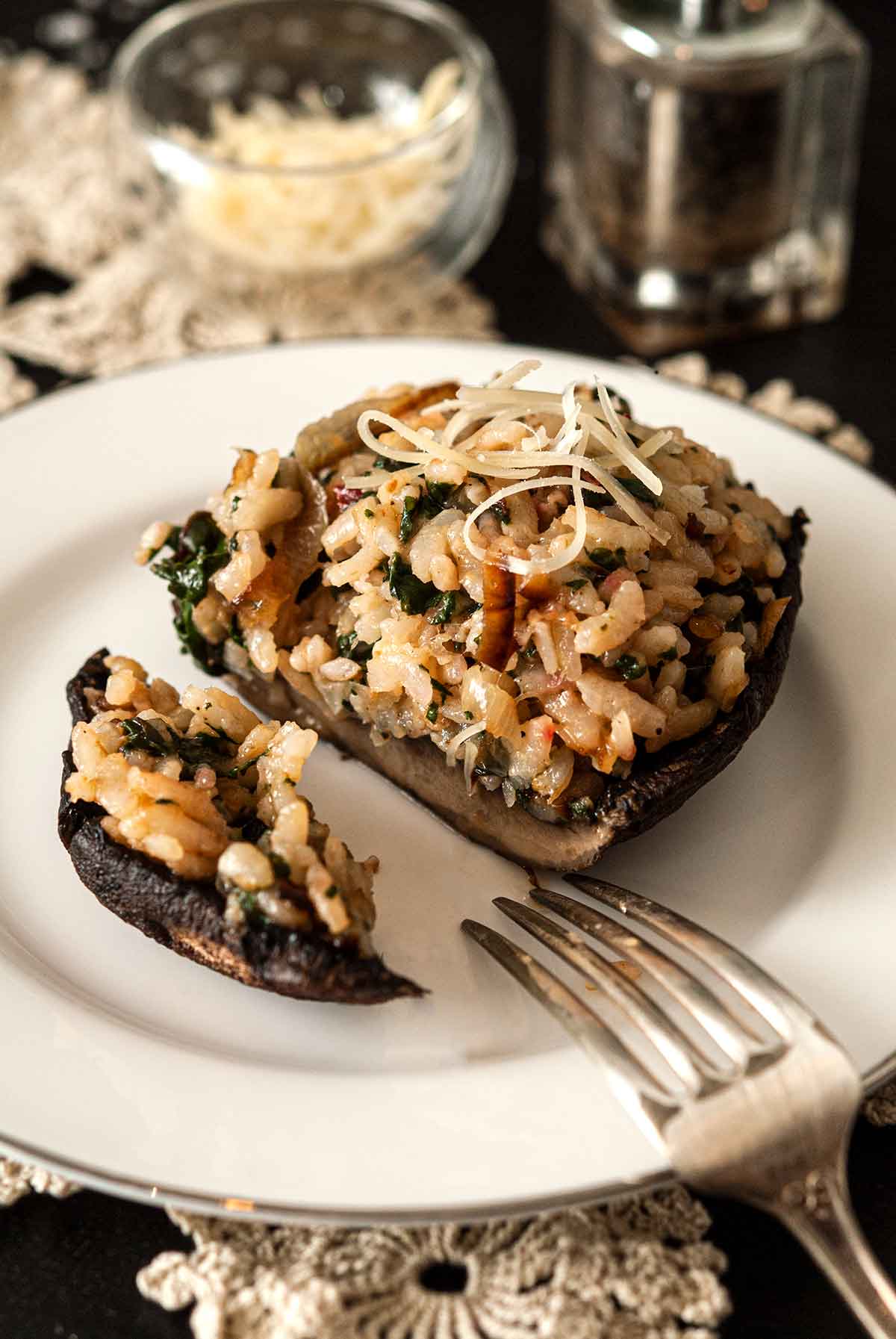 A Risotto-stuffed portobello mushroom, cut on a plate with a fork.