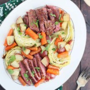 A large serving plate of corn beef and cabbage.