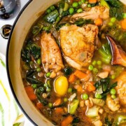 Stout chicken thighs with vegetables in a pot.