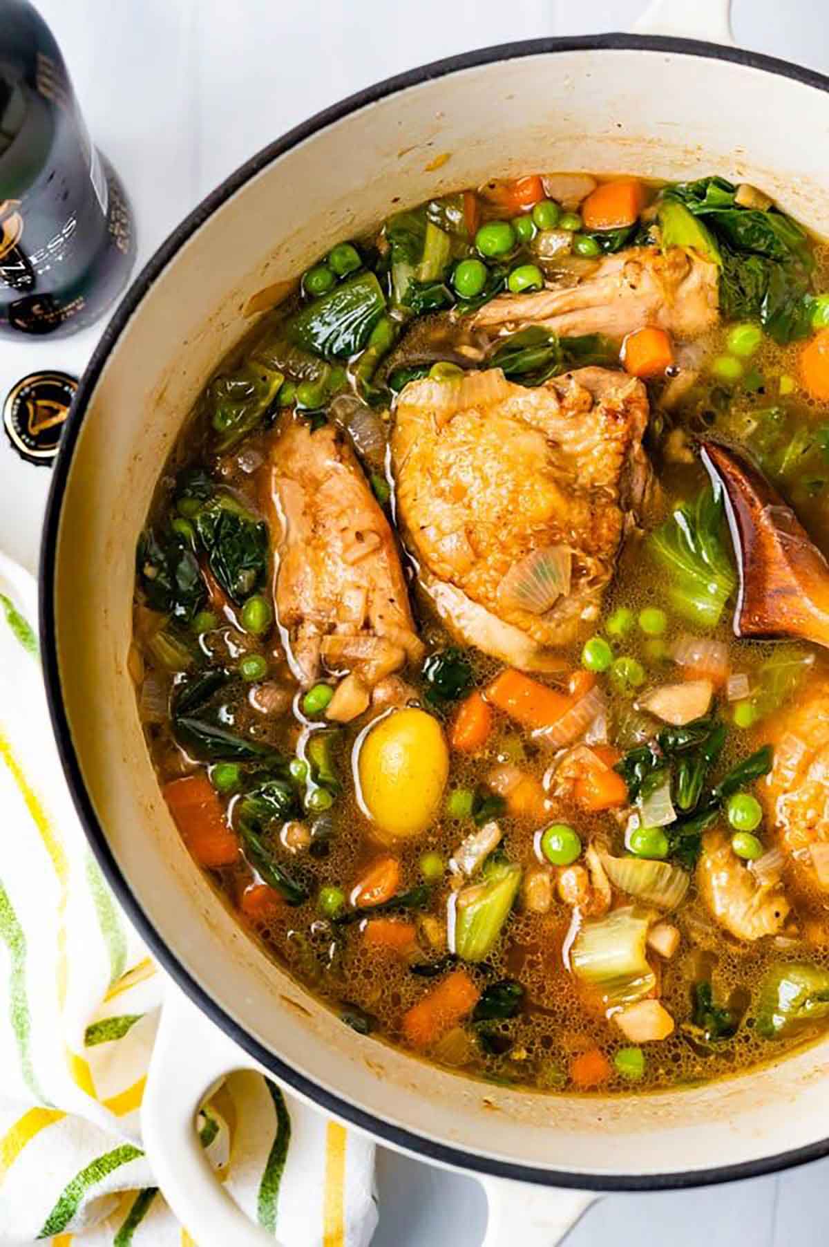 Stout chicken thighs with vegetables in a pot.