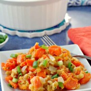 Carrot casserole on a plate with a bowl of casserole in the background.