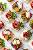 A marble appetizer tray of 8 canapés in 3 different styles.