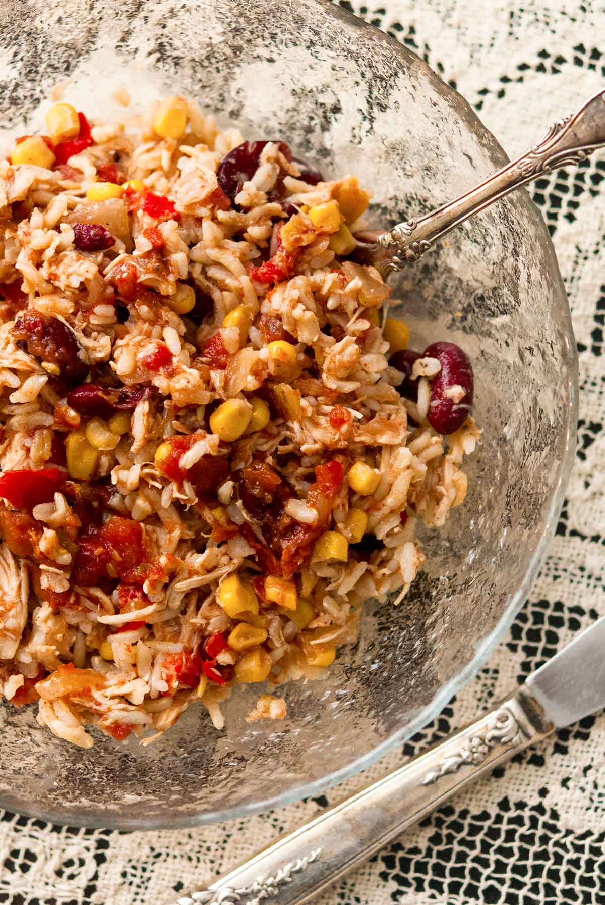 A bowl of Santa Fe chicken on top of a lace table cloth.