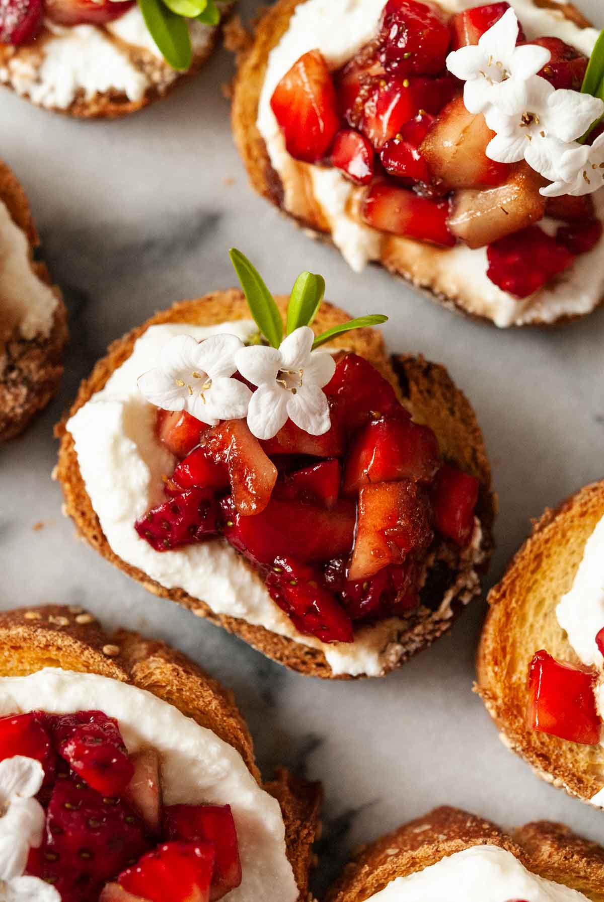 3 strawberry crostini on marble.