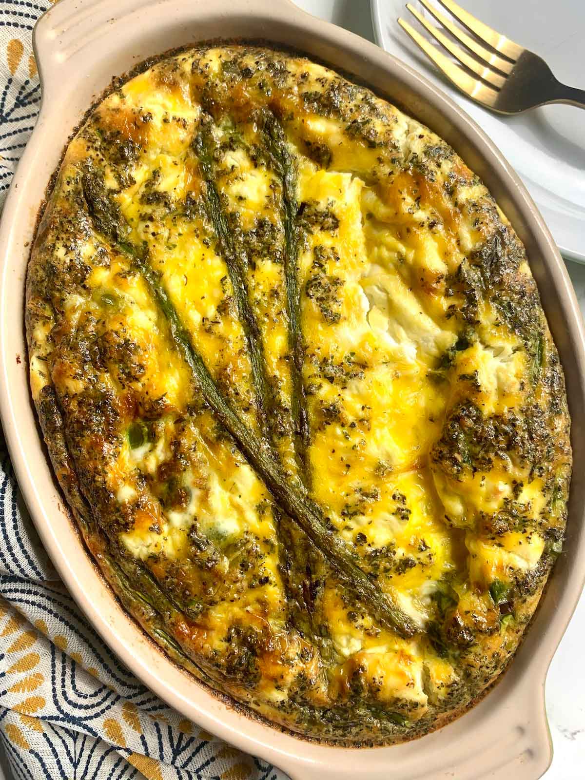 An asparagus frittata in a dish on a table.