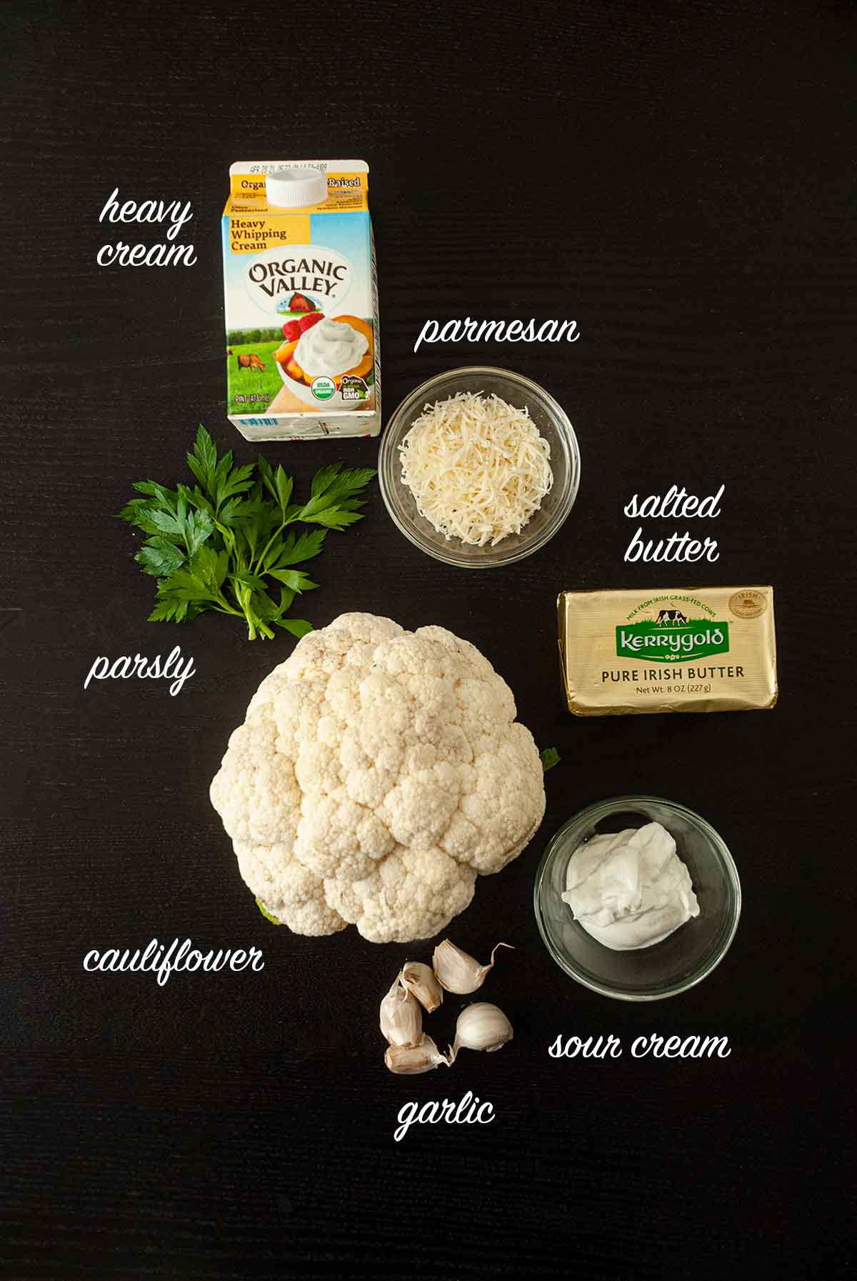 Ingredients on a table for making mashed cauliflower with titles that describe what they are.