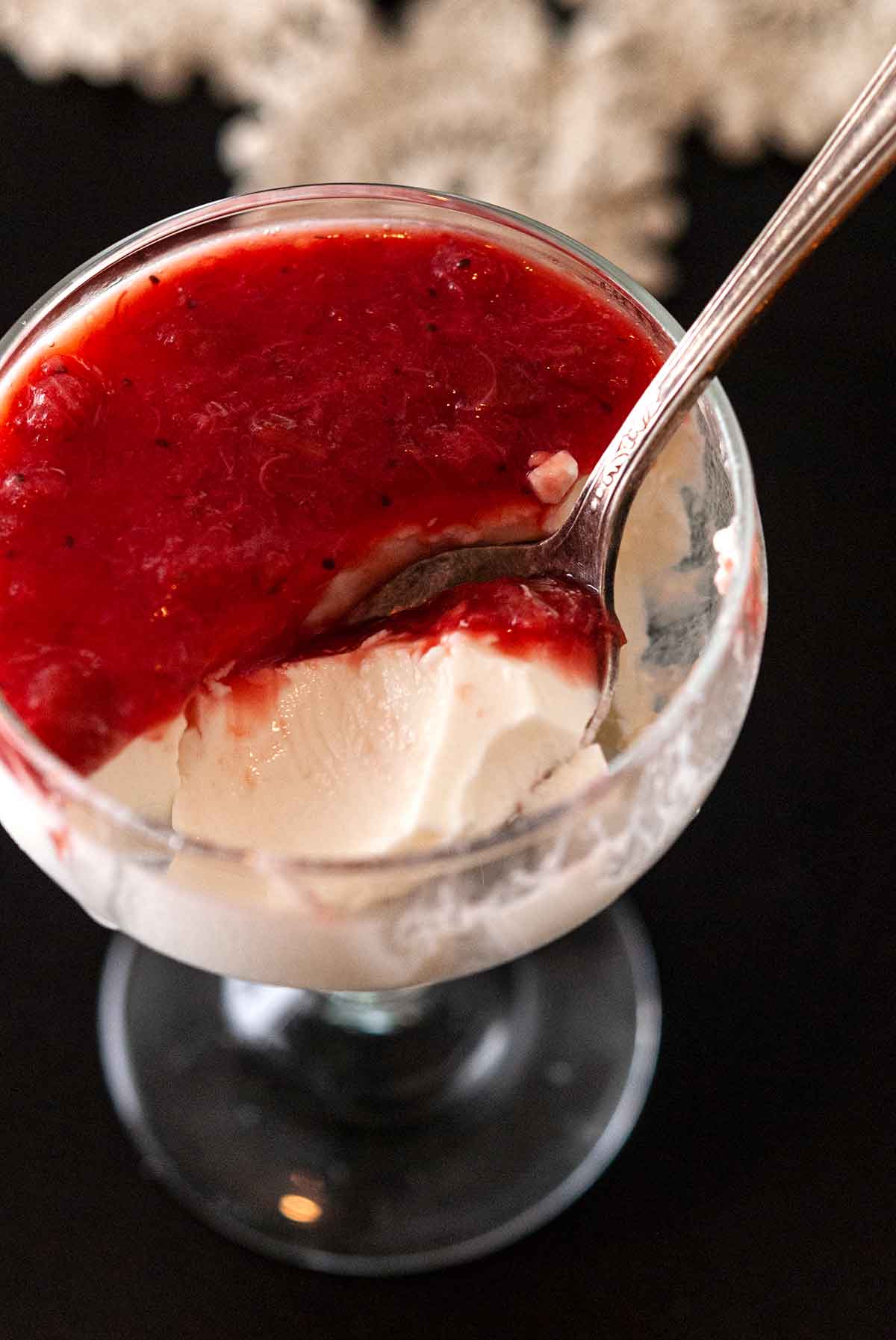 Panna cotta in a glass with a spoon.