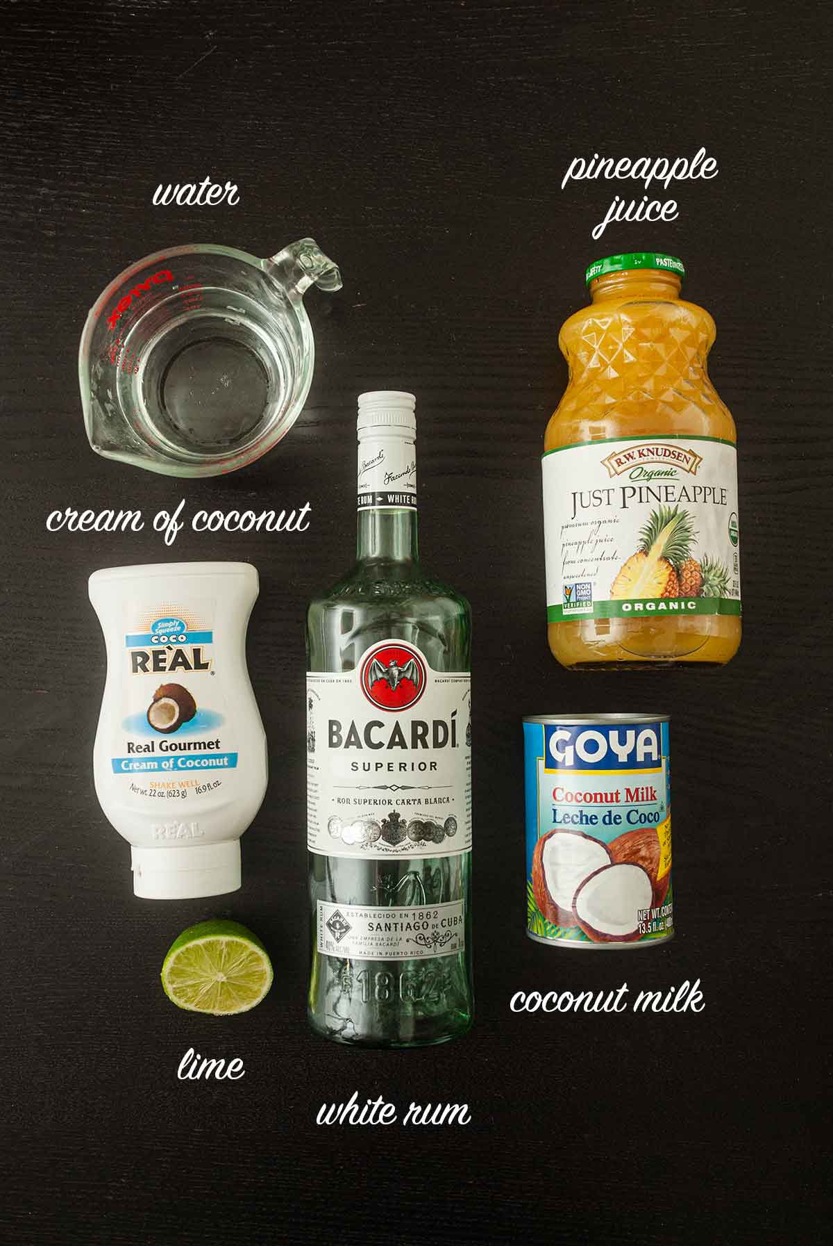 Ingredients for piña coladas on a table with titles.