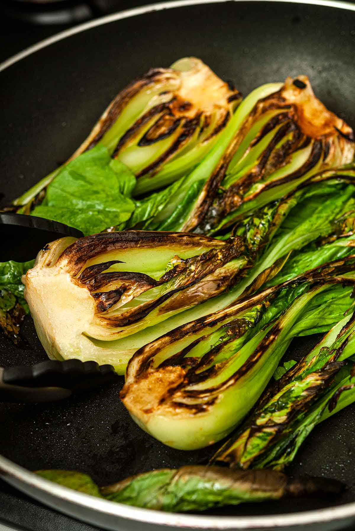4 seared baby bok choy in a pan.