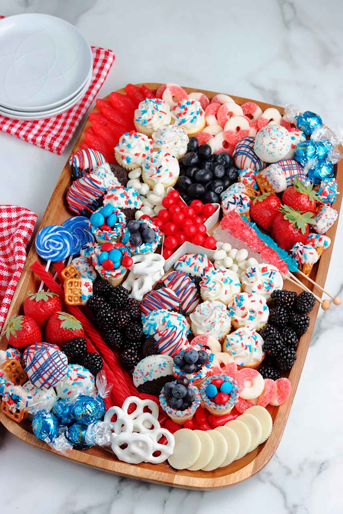 A try filled with red white and blue dessert treats on a table.
