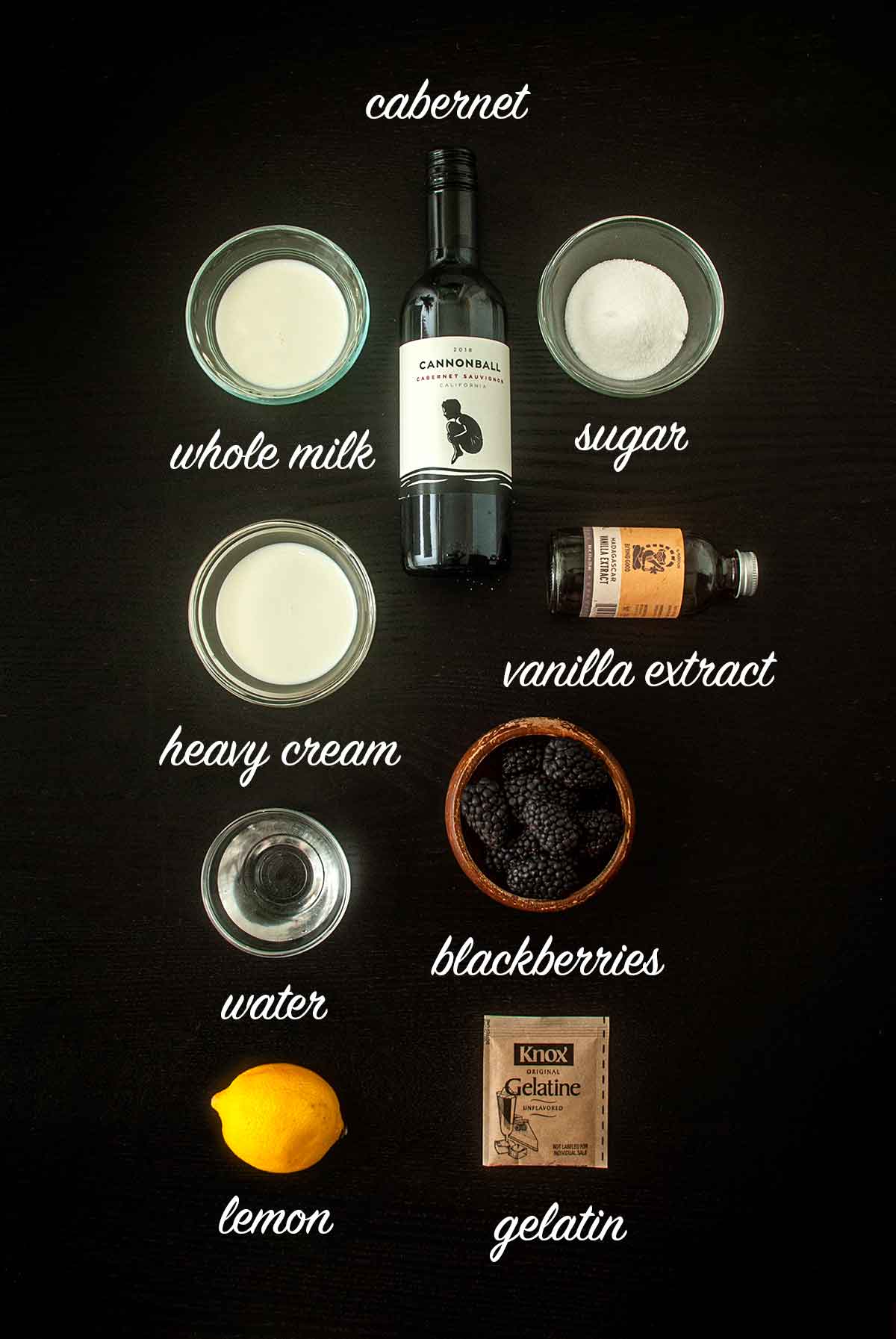 9 ingredients on a table for making panna cotta and berry sauce, with titles describing them.