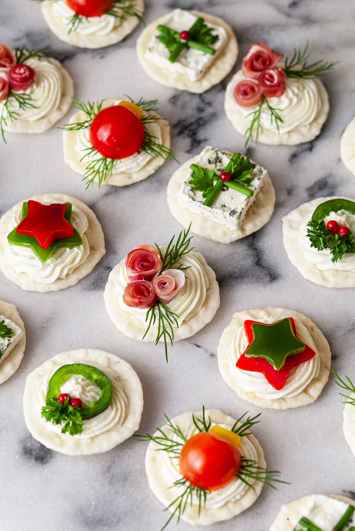 An assortment of 14 holiday-themed appetizers on marble..