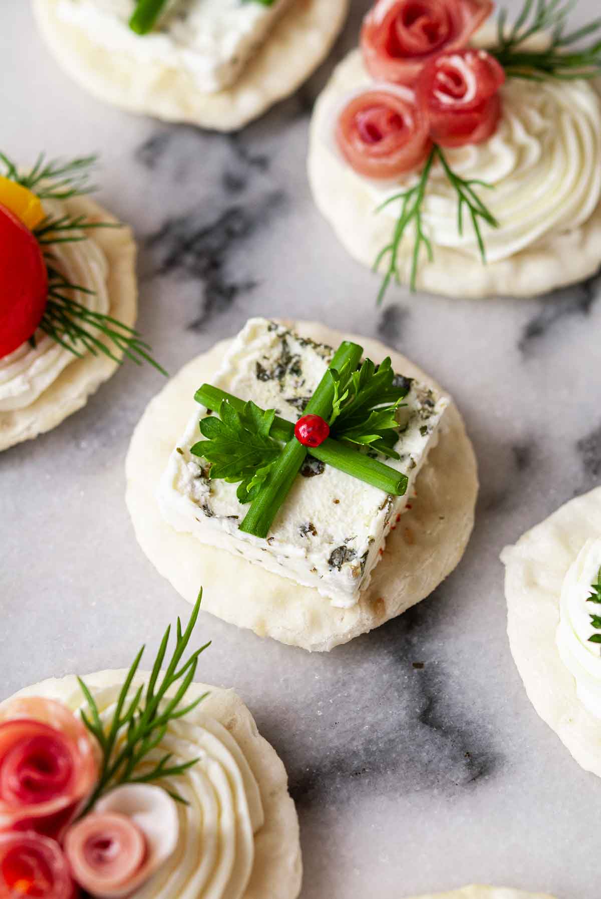 An appetizer that looks like a present on marble with 5 others.