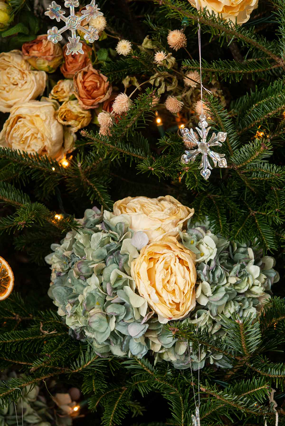 Hydrangea and roses in a Christmas tree with snow flake ornaments.