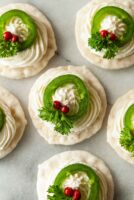 5 jalapeño wreath appetizers on marble with pink peppercorns, cheese and parsley.