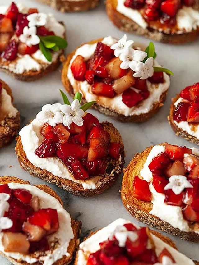 9 strawberry crostini on marble.