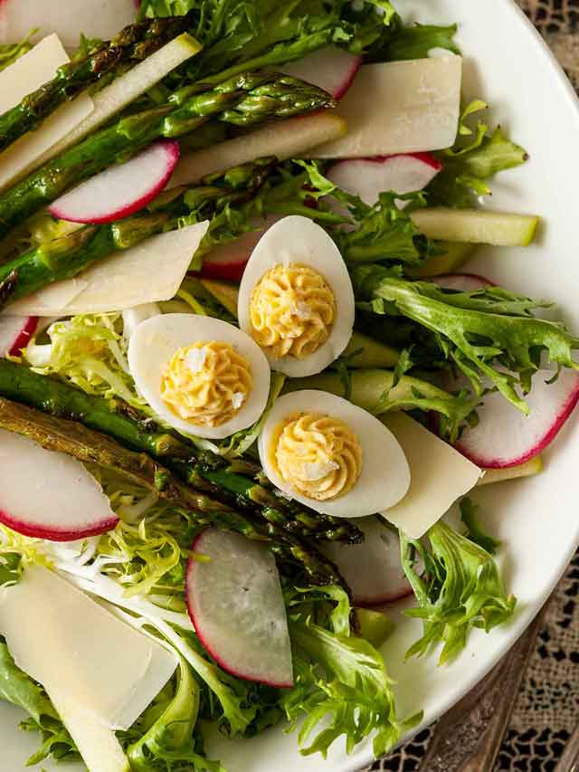 3 small deviled eggs on top of a salad.