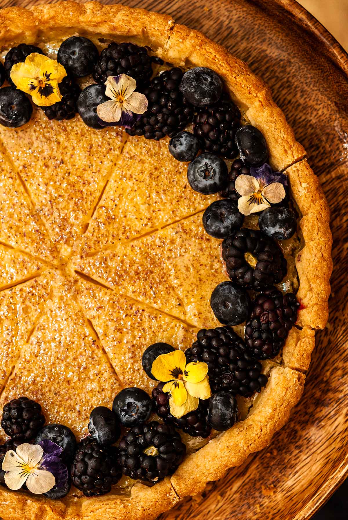 A lemon-lavender tart on a wooden dish.