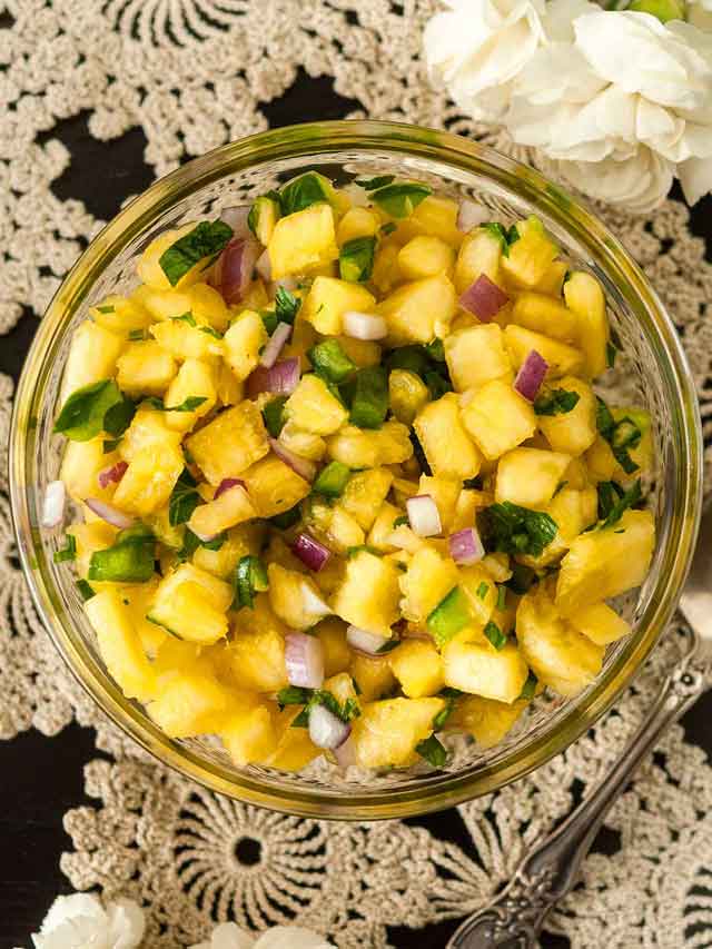 Pineapple jalapeño salsa in a small bowl on a lace tablecloth.