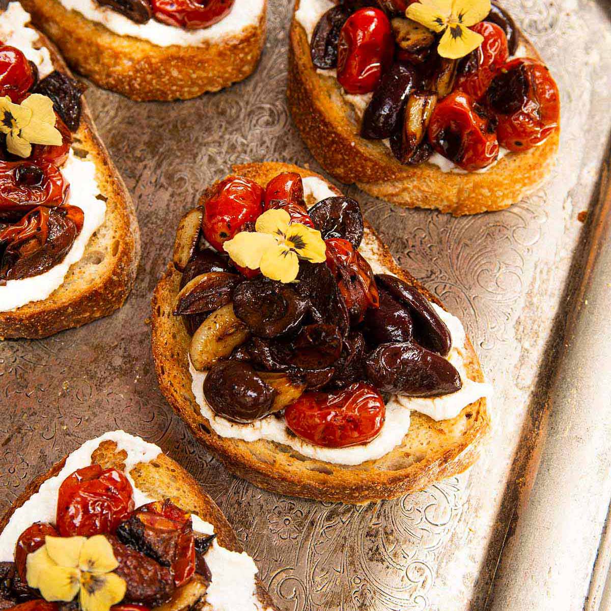 5 bruschetta on a silver platter.