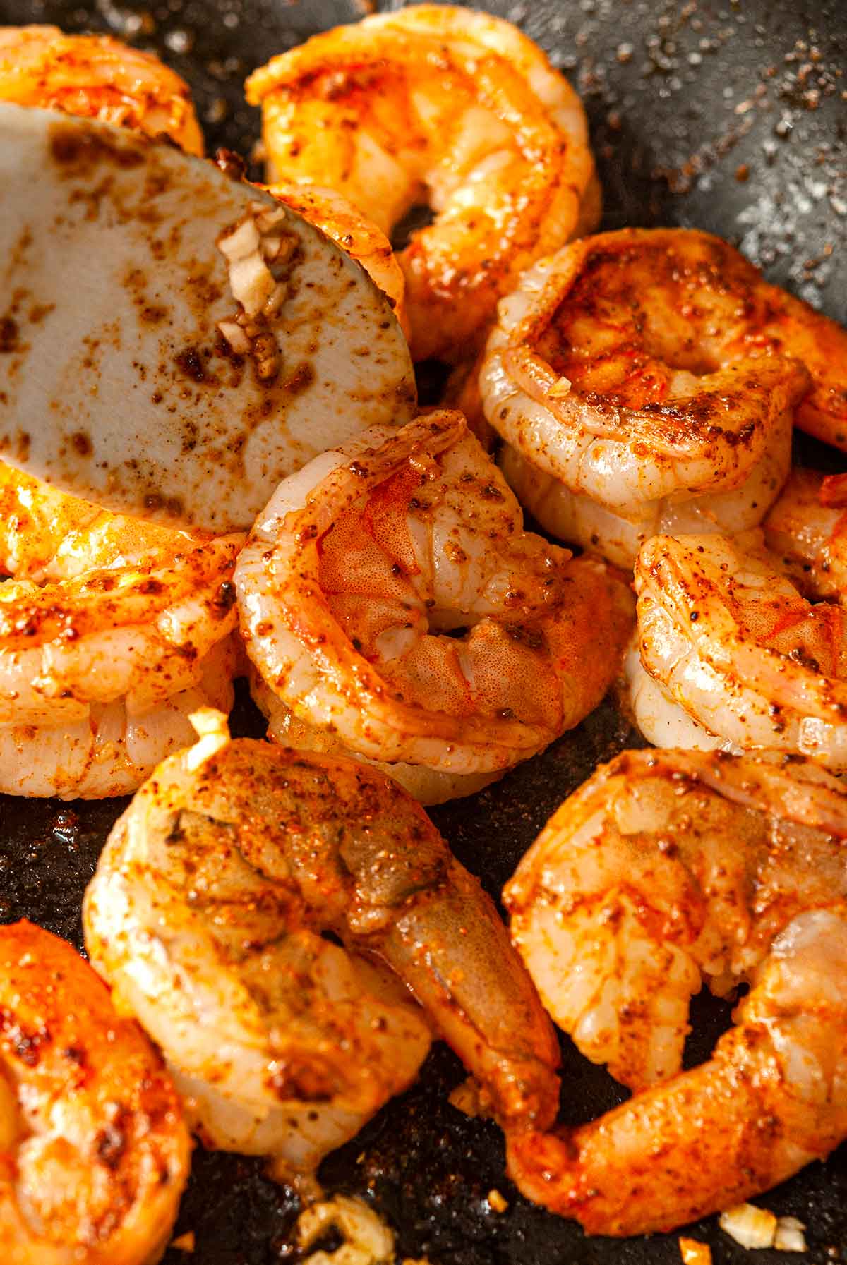 Cilantro lime shrimp in a pan with a spoon.